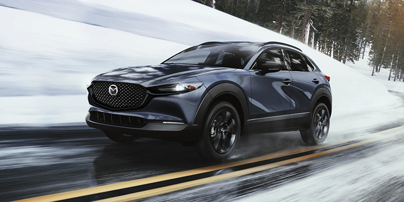 Mazda CX-30 navigating snowy roads with precision and style, showcasing its winter-ready performance.