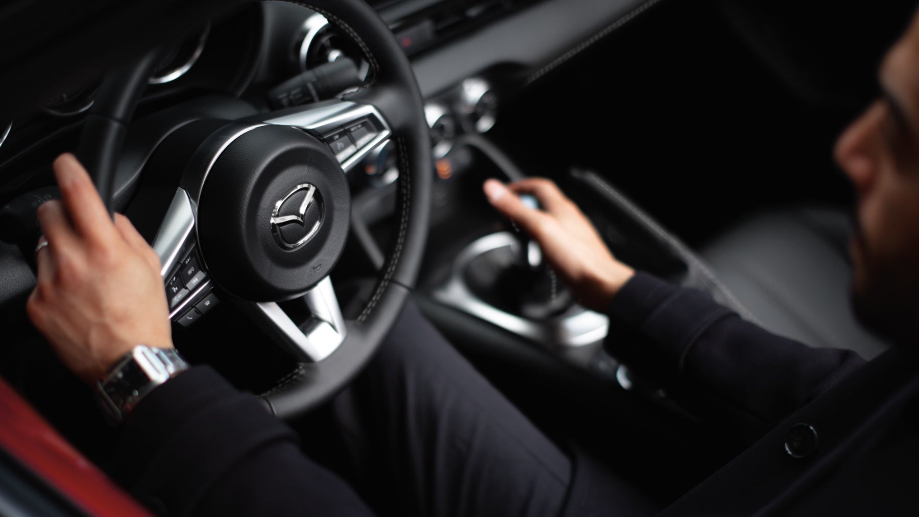 A driver in a Mazda MX-5 Miata